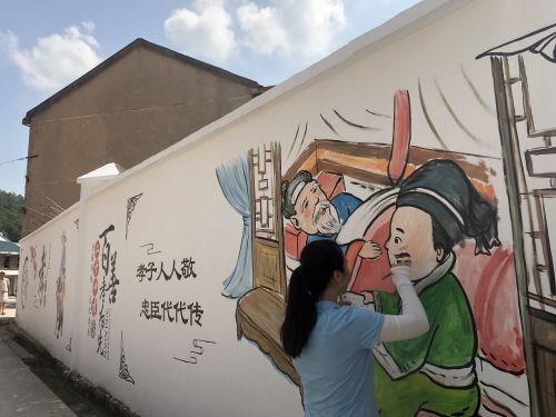 金萍在义乌市苏溪镇立塘村进行孝文化主题墙绘。